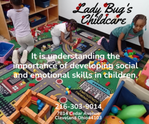 Children playing on the floor, smiling and using building blocks.